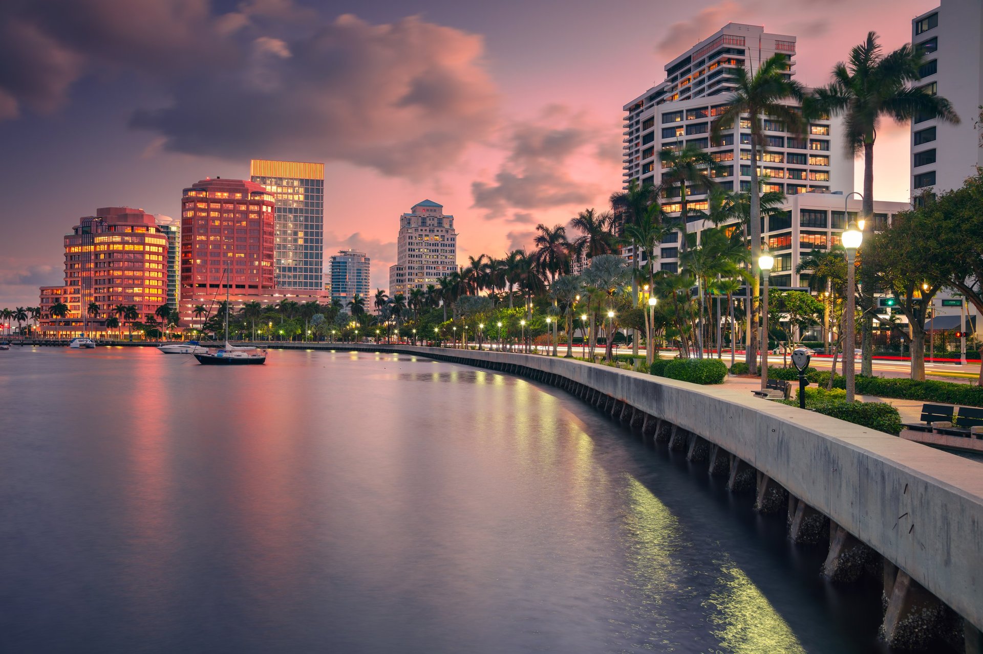 Miami skyline at dusk with illuminated buildings reflecting on Biscayne Bay water